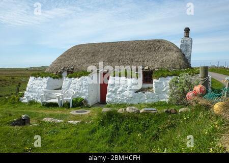 Tradizionale casa nera con paglia sull'isola di Tiree, Scozia, Regno Unito Foto Stock