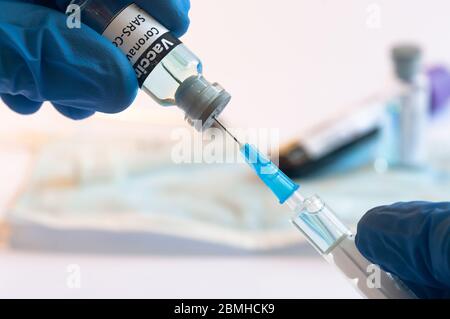 Flaconcino di vaccino per coronavirus COVID-19 e siringa per iniezione in mani mediche Foto Stock