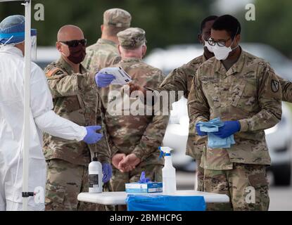 SPC. Nicholas Cisneros consegna un tampone nasale preso da un paziente mentre il team di prova mobile della guardia del Texas (MTT) prova per il coronavirus ad una clinica libera di drive-up nella piccola città centrale del Texas di Taylor. Foto Stock