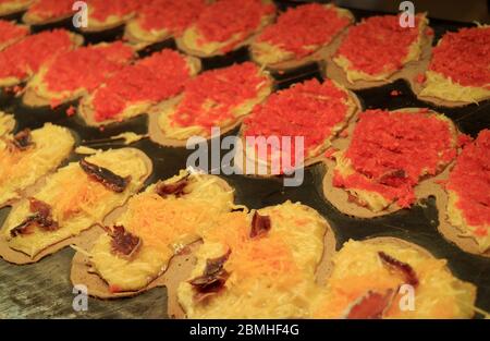 Fila di Crepes croccanti thailandesi chiamata Khanom Bueang, uno dei popolari Street food in Thailandia che viene cucinato su grande piatto Foto Stock