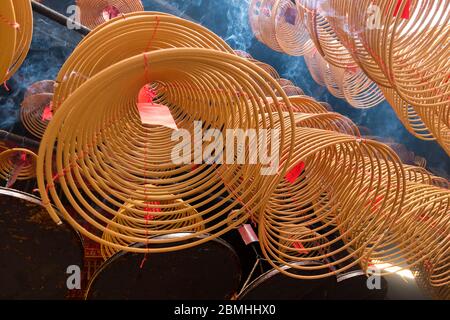 Bastone di incenso beige avvolto appeso in un tempio buddista Foto Stock