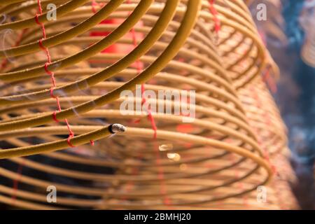 Bastone di incenso beige avvolto appeso in un tempio buddista Foto Stock