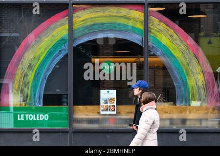 Persone che camminano di fronte ad un negozio con un convid19 arcobaleno di speranza che si attinge su di esso, Montreal Canada Foto Stock