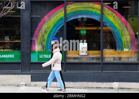 Persone che camminano di fronte ad un negozio con un convid19 arcobaleno di speranza che si attinge su di esso, Montreal Canada Foto Stock