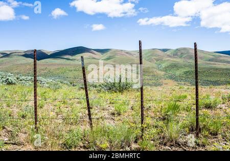 Una recinzione di filo spinato e le colline vicino a Umtanum Ridge a Washington orientale, Stati Uniti. Foto Stock