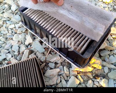 Un vecchio filtro sporco fuori dall'auto. Sostituzione del filtro dell'aria. Foto Stock