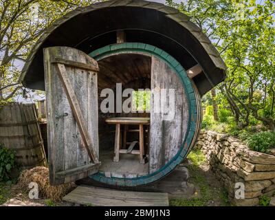 un'enorme botte di vino con un tavolo e panca in esso, giorno di sole in estate Foto Stock