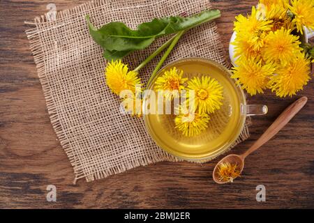 Tazza ph sano tè dente di leone su vintage sfondo di legno. Erbe fresche. Foto Stock