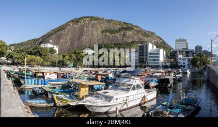 Pescatore locale con maschera in barca piccola docking nella zona del porto della baia di Guanabara a Rio de Janeiro, Brasile Foto Stock