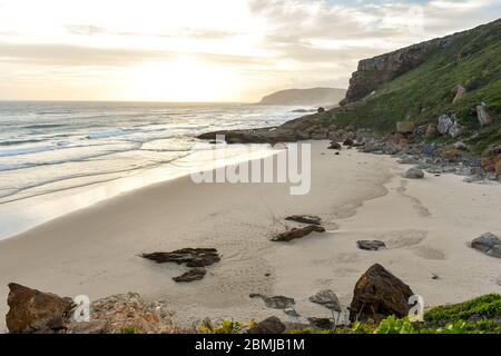 Tramonto presso la spiaggia di Robberg e la riserva naturale di Robberg vicino alla baia di Plettenberg, Garden Route, Sudafrica Foto Stock