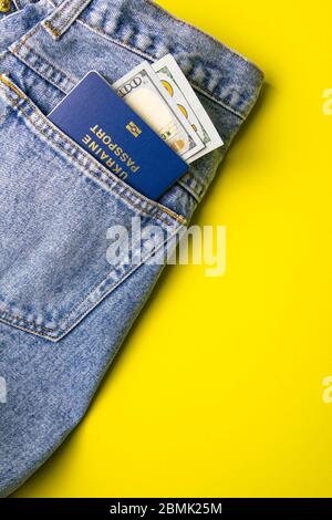 Denaro da tasca in jeans blu con passaporto - dollari USA su yallow background Foto Stock