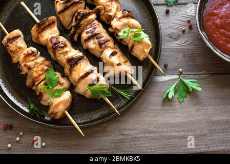 Spiedini di pollo alla griglia sul piatto da vicino. Carne di maiale, pollo o tacchino shish kebab con erbe e spezie, pasto barbecue. Foto Stock