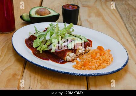 Enchiladas messicano rojas con lattuga di pollo e cipolle alimentare in Messico Foto Stock