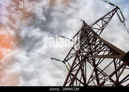 Torre elettrica ad alta tensione all'ora del tramonto e cielo sullo sfondo del tramonto. Foto Stock