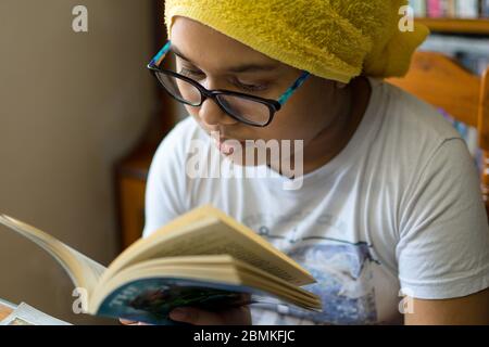 La ragazza indiana piccola studia a casa mantenendo la distanza sociale durante il periodo di blocco per Covid-19. Foto Stock
