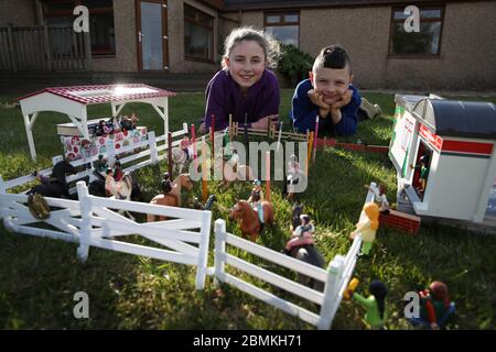 Embargoed a 0001 Lunedi 11 maggio Ailie e Hamish Muirhead accanto alla loro riproduzione giocattolo del Royal Highland Show a Edimburgo. Dopo questo anno l'evento fu annullato a causa dell'epidemia di coronavirus, Ailie, 12, e suo fratello Hamish, otto, che normalmente partecipano all'evento, decise di ricreare i propri da Lego e Playmobil nel loro giardino. Foto Stock