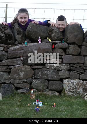 Embargoed a 0001 Lunedi 11 maggio Ailie e Hamish Muirhead insieme alla loro riproduzione giocattolo del Royal Highland Show a Edimburgo. Dopo questo anno l'evento fu annullato a causa dell'epidemia di coronavirus, Ailie, 12, e suo fratello Hamish, otto, che normalmente partecipano all'evento, decise di ricreare i propri da Lego e Playmobil nel loro giardino. Foto Stock