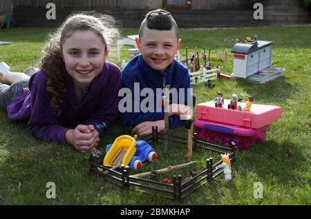 Embargoed a 0001 Lunedi 11 maggio Ailie e Hamish Muirhead accanto alla loro riproduzione giocattolo del Royal Highland Show a Edimburgo. Dopo questo anno l'evento fu annullato a causa dell'epidemia di coronavirus, Ailie, 12, e suo fratello Hamish, otto, che normalmente partecipano all'evento, decise di ricreare i propri da Lego e Playmobil nel loro giardino. Foto Stock