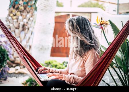 Alternative persone adulte moderne in attività di lavoro intelligente all'aperto a casa nel giardino - concetto di tecnologia moderna che lavora ovunque - connesso Foto Stock