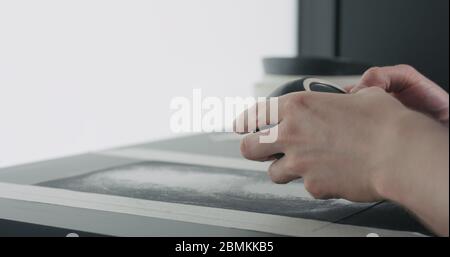 controllare il fondo della ciotola nera in ceramica con le mani dell'uomo Foto Stock