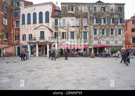 Venezia, Italia - 16 ottobre 2016: Tipica piazza della città veneziana con ristorante e palazzi antichi Foto Stock