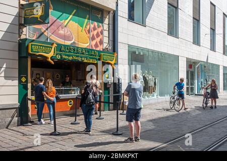 Clienti che attendono fuori linea di fronte al gelateria nel corso del 2020 COVID-19 / coronavirus / pandemia del virus corona a Gand, Belgio, città fiamminga Foto Stock