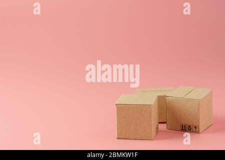Concetto di shopping : cartoni o scatole di carta su sfondo rosa. I consumatori di shopping online possono acquistare da casa e servizio di consegna. Con spazio copia Foto Stock