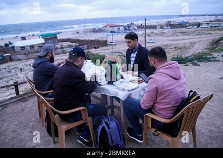 Gaza, Palestina. 9 maggio 2020. I palestinesi rompono il loro digiuno e cenano con il loro iftar sulle rive di Gaza durante il mese sacro musulmano del Ramadan. IFTAR è la cena consumata dalle famiglie alla fine il quotidiano Ramadan veloce. Durante quest'anno i Ramadan Gazan devono affrontare la minaccia del Covid-19, oltre alle consuete interruzioni di corrente e crisi economica. Credit: ZUMA Press, Inc./Alamy Live News Foto Stock