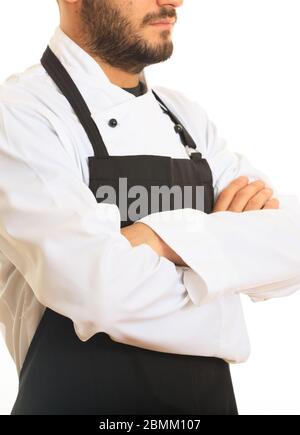 Chef con uniforme bianca e grembiule nero in piedi con mani incrociate su sfondo bianco. Preparazione del menu del ristorante. Verticale verticale. Foto Stock