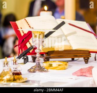 altare con ostia che diventa corpo di gesù cristo e calice per il vino, sangue di cristo, con il libro per la messa dei fedeli Foto Stock