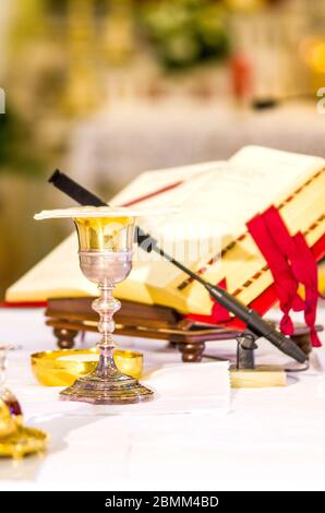 altare con ostia che diventa corpo di gesù cristo e calice per il vino, sangue di cristo, con il libro per la messa dei fedeli Foto Stock