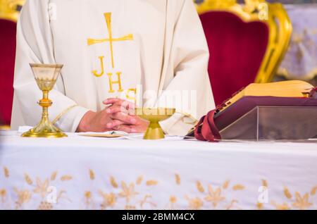 altare con ostia che diventa corpo di gesù cristo e calice per il vino, sangue di cristo, con il libro per la messa dei fedeli Foto Stock