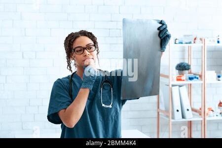 Medico veterinario pensivo che studia la scansione a raggi X in clinica animale Foto Stock