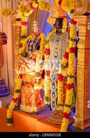 Gli idoli di Lord Balaji e Lakshmi decorati con fiori e ornamenti in un matrimonio indù Foto Stock