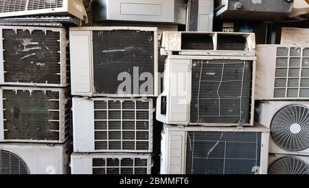 Un gruppo di compressori di aria condizionata sporchi, polverosi e rotti è accatastato in una discarica. Molti vecchi condizionatori d'aria e sulla strada vicino alla re Foto Stock