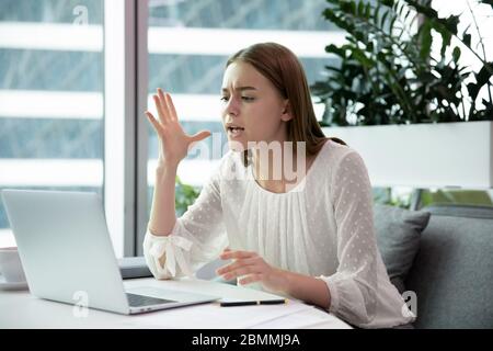 Una donna d'affari arrabbiata che ha problemi con il computer si sente infastidita Foto Stock