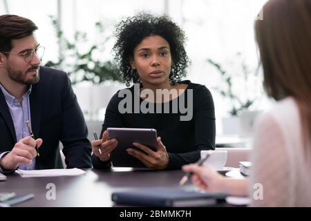 I partner multietnici si sono riuniti in sala di consiglio per negoziare la soluzione delle questioni attuali Foto Stock
