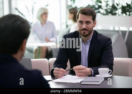 Il responsabile delle risorse umane ascolta il candidato durante il processo di colloquio di lavoro Foto Stock