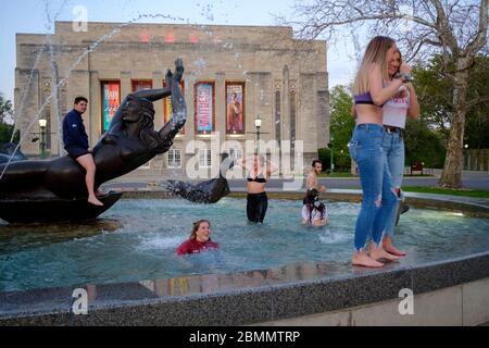 Bloomington, Stati Uniti. 9 maggio 2020. Un gruppo di studenti dell'Indiana University che hanno appena terminato di laurearsi alla Kelley School of Business durante una video cerimonia questo fine settimana festeggia dopo saltando nelle acque della Show-Alter Fountain e posando per photographs.Lezioni a IU sono stati insegnati virtualmente dalla pausa primaverile a causa della pandemia COVID-19/Coronavirus, e le lezioni di persona sono state annullate e la cerimonia di laurea annuale di persona è stata annullata. Credit: SOPA Images Limited/Alamy Live News Foto Stock