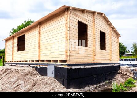 Costruzione di una nuova casa in legno sulla fondazione in pietra Foto Stock