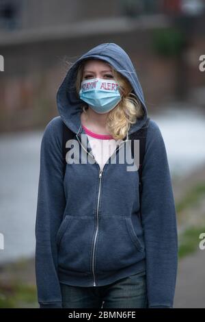 Manchester, Regno Unito. 10 maggio 2020. Una ragazza che cammina vicino al canale Rochdale di Ancoats, Manchester, indossando una maschera facciale con le parole 'Stayin' Alert' su di esso in inchiostro rosso Domenica 10 maggio 2020. (Credit: Pat Scaasi | MI News) Credit: MI News & Sport /Alamy Live News Foto Stock