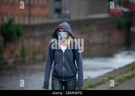 Manchester, Regno Unito. 10 maggio 2020. Una ragazza che cammina vicino al canale Rochdale di Ancoats, Manchester, indossando una maschera facciale con le parole 'Stayin' Alert' su di esso in inchiostro rosso Domenica 10 maggio 2020. (Credit: Pat Scaasi | MI News) Credit: MI News & Sport /Alamy Live News Foto Stock