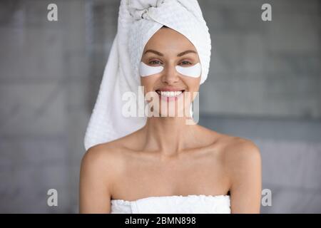 Bella donna che si prende cura della pelle applicare le patch idrogel anti rughe Foto Stock