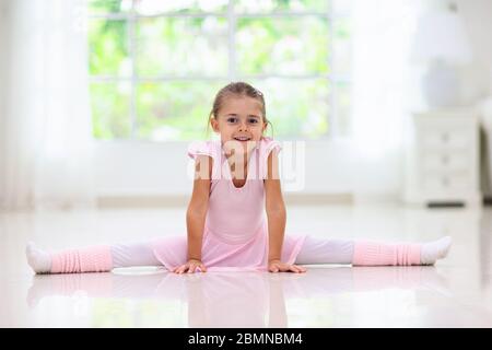 Allenamento a casa con balletto. Apprendimento remoto. Piccola ballerina in classe di danza. Ragazza carina in tutu e leotard imparare a ballare. Coreografia classica per bambini Foto Stock