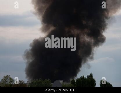 Berlino, Germania. 10 maggio 2020. Una nuvola di fumo oscura si erge sopra Berlino-Tegel. Secondo i primi rapporti del reparto antincendio, diversi magazzini di Flohrstraße avevano preso fuoco. L'area delle operazioni è stata corrodonata su una vasta area. Anche il traffico sulla strada statale adiacente è stato interrotto. (Al dpa: 'I magazzini sempreverdi stanno bruciando a Tegel - distribuzione su larga scala dei vigili del fuoco') Credit: Paul Zinken/dpa-zentralbild/dpa/Alamy Live News Foto Stock