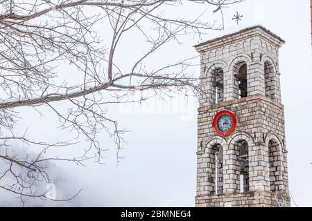 Paesaggio invernale con campanile di una chiesa cristiana ortodossa, nel villaggio di Mikro Chorio, vicino a Karpenissi, nella Grecia centrale, in Europa. Foto Stock