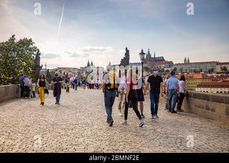 Praga, repubblica Ceca - 8.05.2020: Persone in maschere che camminano lungo il Ponte Carlo a Praga, Repubblica Ceca durante la quarantena Foto Stock