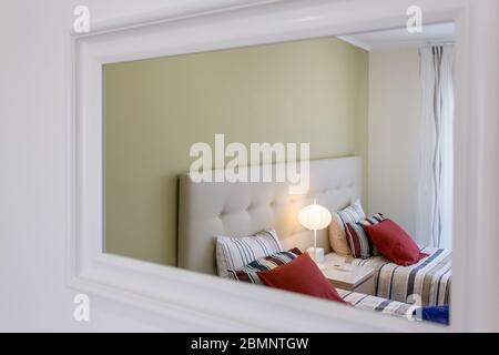 Camera da letto moderna, che si riflette nello specchio. Design europeo e interno. Foto Stock