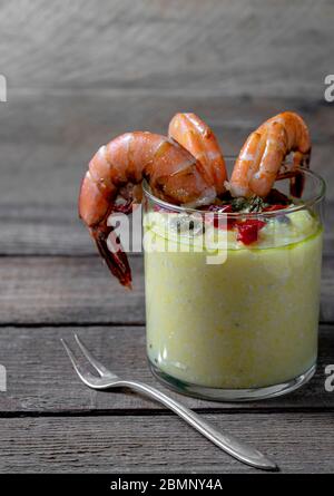 Antipasto di gamberi alla griglia con polenta di formaggio ripiena di vetro con pesto e peperoni rossi arrostiti. Nessuna gente. Foto Stock