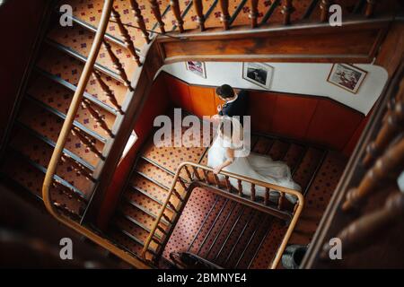 sposa e sposo scendendo lungo una vecchia scala Foto Stock